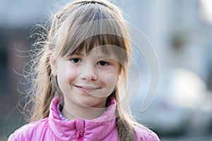 Portrait of happy child girl in warm clothes in autumn outdoors