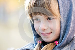 Portrait of happy child girl in warm clothes in autumn outdoors