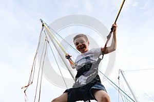 Happy child jumping on bungee trampoline