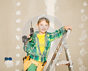 Portrait of a happy child on a ladder with tools and tool