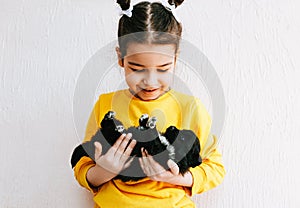 Portrait of a happy child smiling and playing at home with little dog. Pretty little girl cares about the puppy. Happy kid playing