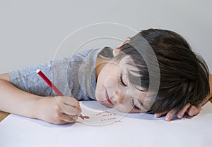 Portrait of happy child writing a messages to his mother, Preschool kid using red colour writing and drawing on white paper, Littl