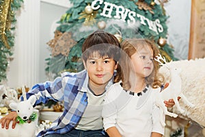 Portrait of a happy children - boy and girl. Little kids in Christmas decorations. Brother and sister