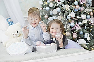 Portrait of a happy children - boy and girl. Little kids in Christmas decorations. Brother and sister