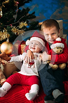 Portrait of happy children with Christmas gift boxes and decorations. Two kids having fun at home