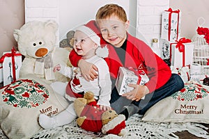 Portrait of happy children with Christmas gift boxes and decorations. Two kids having fun at home