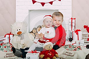 Portrait of happy children with Christmas gift boxes and decorations. Two kids having fun at home