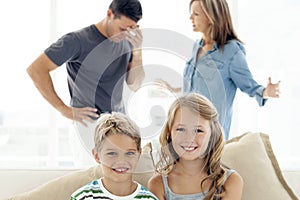 Portrait of happy children - parents arguing in background
