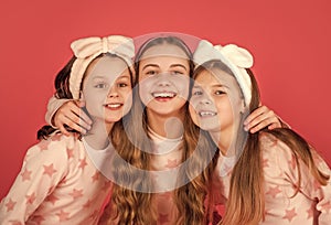 Portrait of happy children with smiling faces in homewear pink background