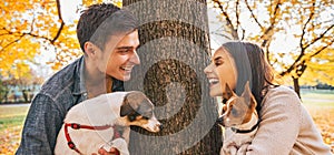 Portrait of happy couple with dogs outdoors in autumn park