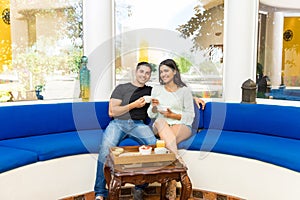 Portrait Of Happy Couple Having Breakfast Together On Sofa