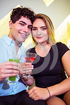 Portrait of happy couple holding cocktail glasses