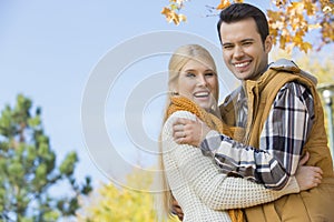 Portrait of happy couple hugging in park