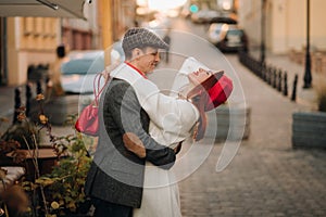 Portrait of a happy couple hugging on the street in an autumn city. Retro stylish couple in autumn in the city