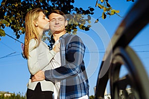 Portrait of a happy couple hugging in the street, in the city.standing in better from the sun, hard light. date