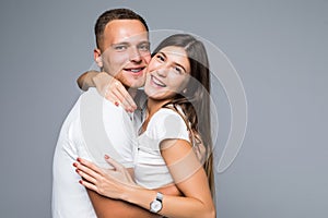 Portrait of happy couple looking at camera against gray background