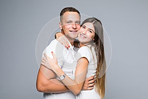 Portrait of happy couple looking at camera against gray background