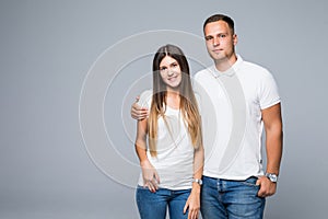 Portrait of happy couple looking at camera on gray background