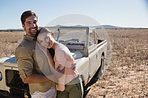 Portrait of happy couple by off road vehicle