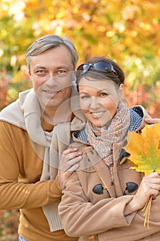 Portrait of happy couple posing in autumnal park