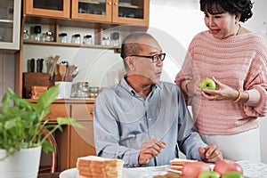 Portrait of happy couple senior asia woman and retirement man having breakfast together