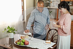 Portrait of happy couple senior asia woman and retirement man having breakfast together