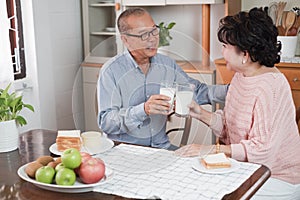 Portrait of happy couple senior asia woman and retirement man having breakfast together