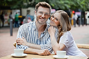 Portrait of happy couple sitting at sidewalk cafe