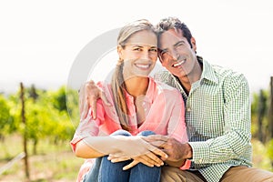 Portrait of happy couple sitting in vineyard