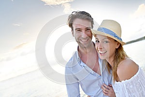 Portrait of happy couple in sunset walking on the beach