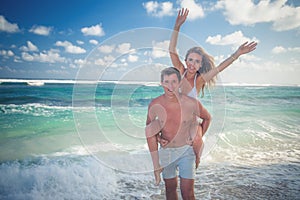 Portrait of happy couple taveling at Bali, walk at beach