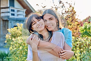 Portrait of happy couple of teenagers friends hugging, outdoor