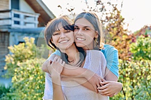 Portrait of happy couple of teenagers friends hugging, outdoor
