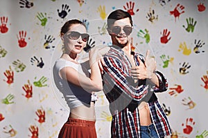 Portrait of happy couple with thumbs up sign on a funny positive background