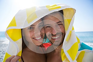 Portrait of happy couple under towel on sunny day