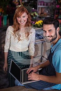 Portrait of happy couple using laptop