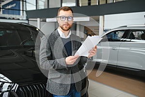 Portrait of happy customer buying new car.