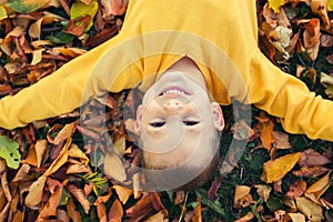 Portrait of happy cute boy with autumn leaves background.