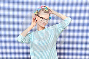 Portrait of happy cute girl with bright colorful hair curlers on head