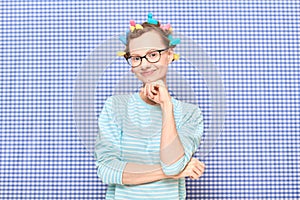 Portrait of happy cute girl with bright colorful hair curlers on head