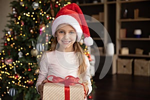 Portrait of happy cute girl holding wrapped gift.