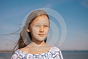 Portrait of Happy Cute Girl in During Summer Vacation On Exotic Tropical Beach. Wind in a hair. Family Journey