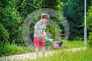 Portrait of a happy cute little boy holding pinwheel at the park. kid hold in hand play with windmill. boy smiling in spring or