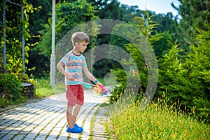 Portrait of a happy cute little boy holding pinwheel at the park. kid hold in hand play with windmill. boy smiling in spring or