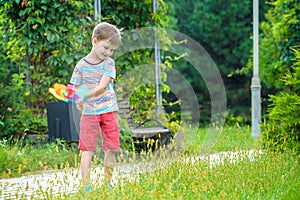 Portrait of a happy cute little boy holding pinwheel at the park. kid hold in hand play with windmill. boy smiling in spring or