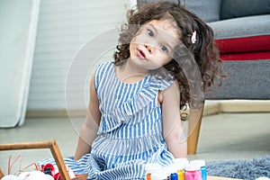 Portrait happy cute little girl preparing colorful paint easter eggs