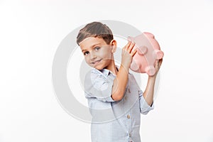 Portrait of a happy cute little kid holding piggy bank