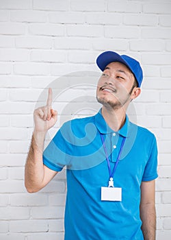 Portrait of happy delivery man point and look up