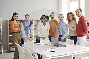 Portrait of happy diverse business team standing in office after successful work meeting