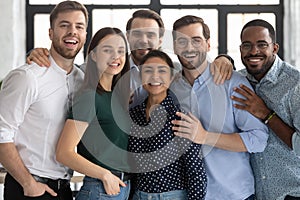Portrait of happy diverse colleagues posing together in office